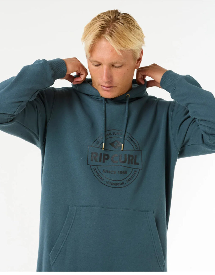 Man wearing Rip Curl Stapler Hood in teal with chest logo print