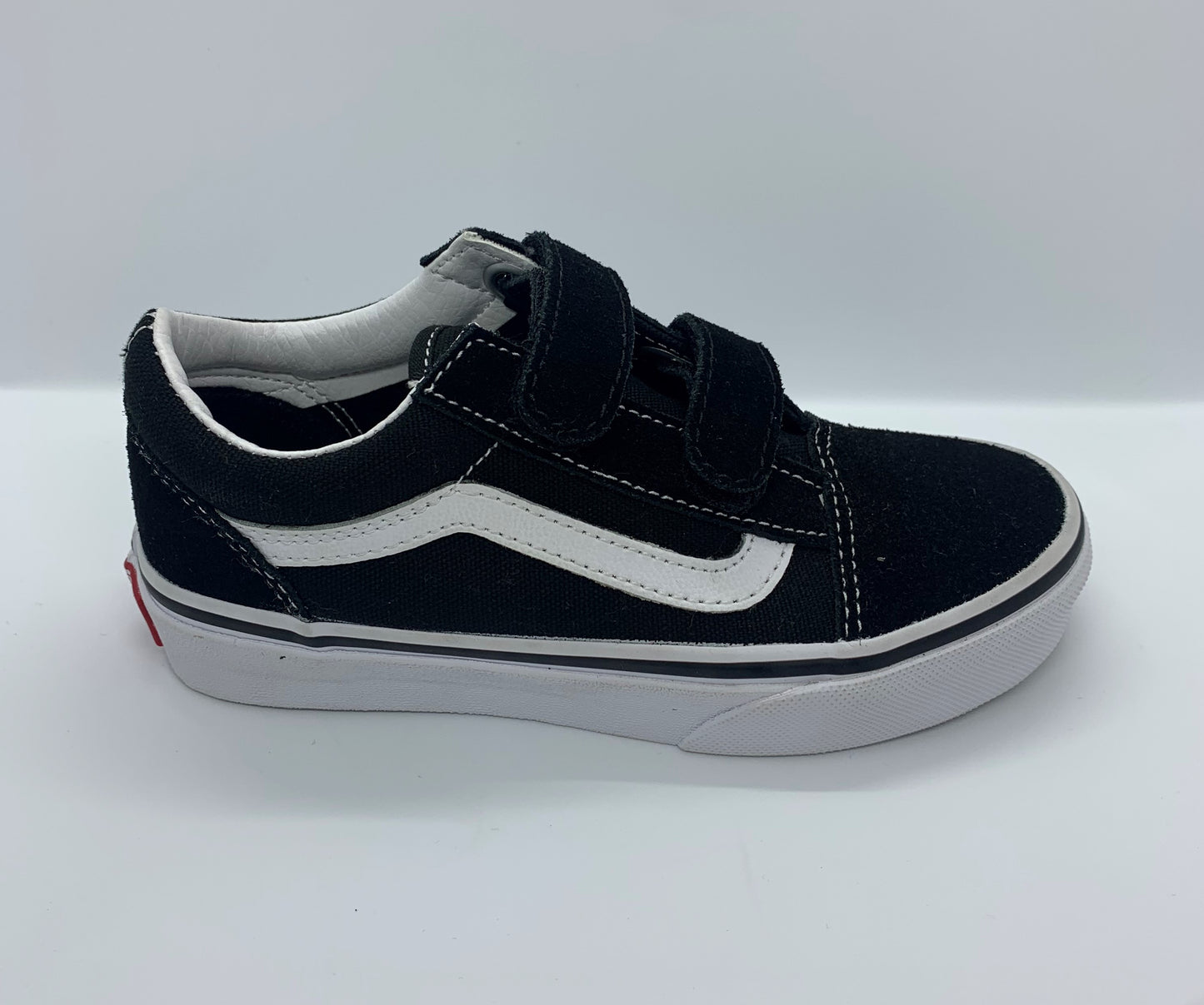 Top Side view of black Vans Old Skool V Kids sneakers with white stripe and double velcro straps