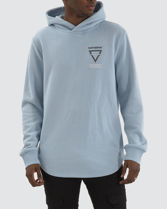 Model wearing NXP Defend Dual Curved Hoodie in Skyway blue with chest logo and curved hem – modern men’s streetwear.